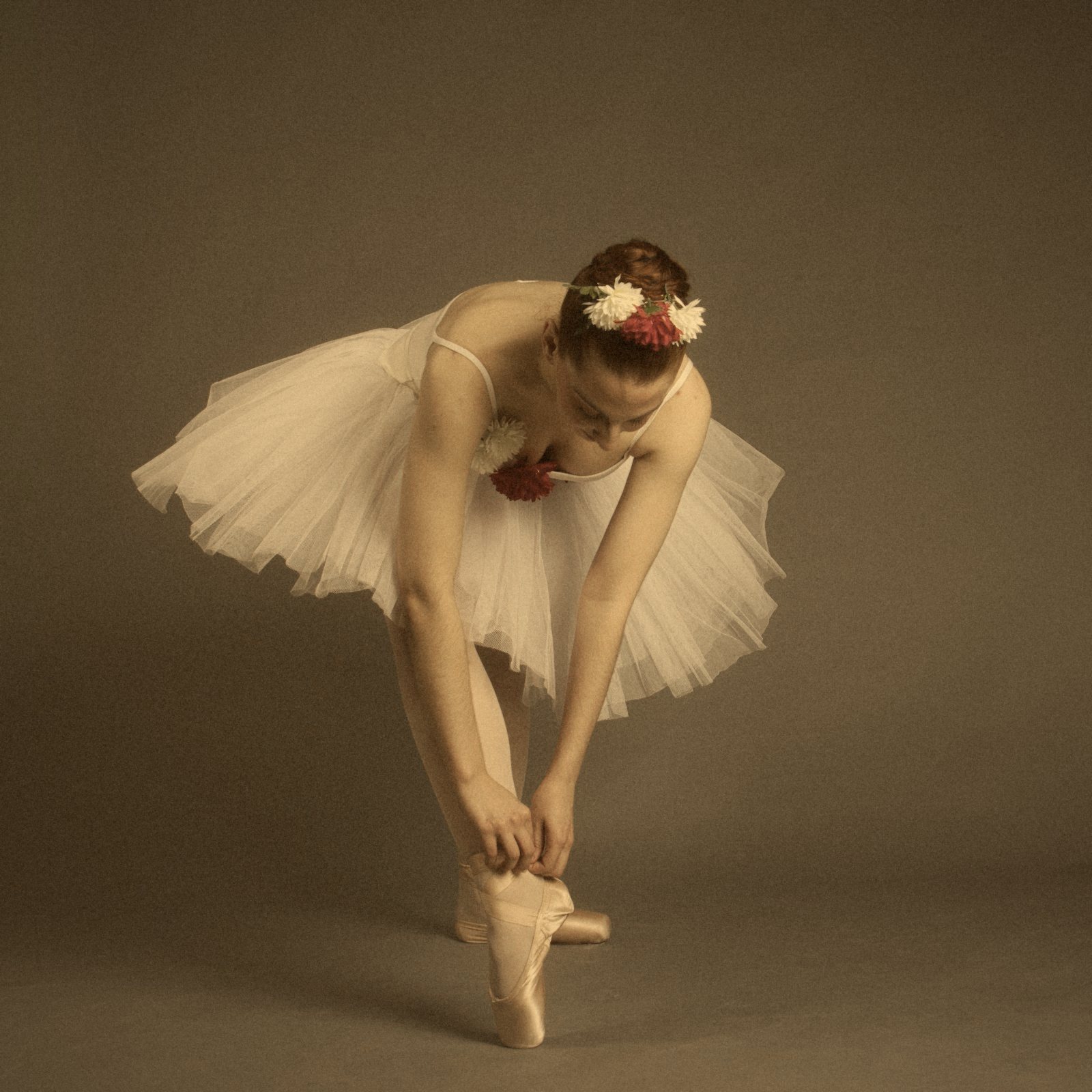 Bailarina con tutú inclinada para atarse la punta