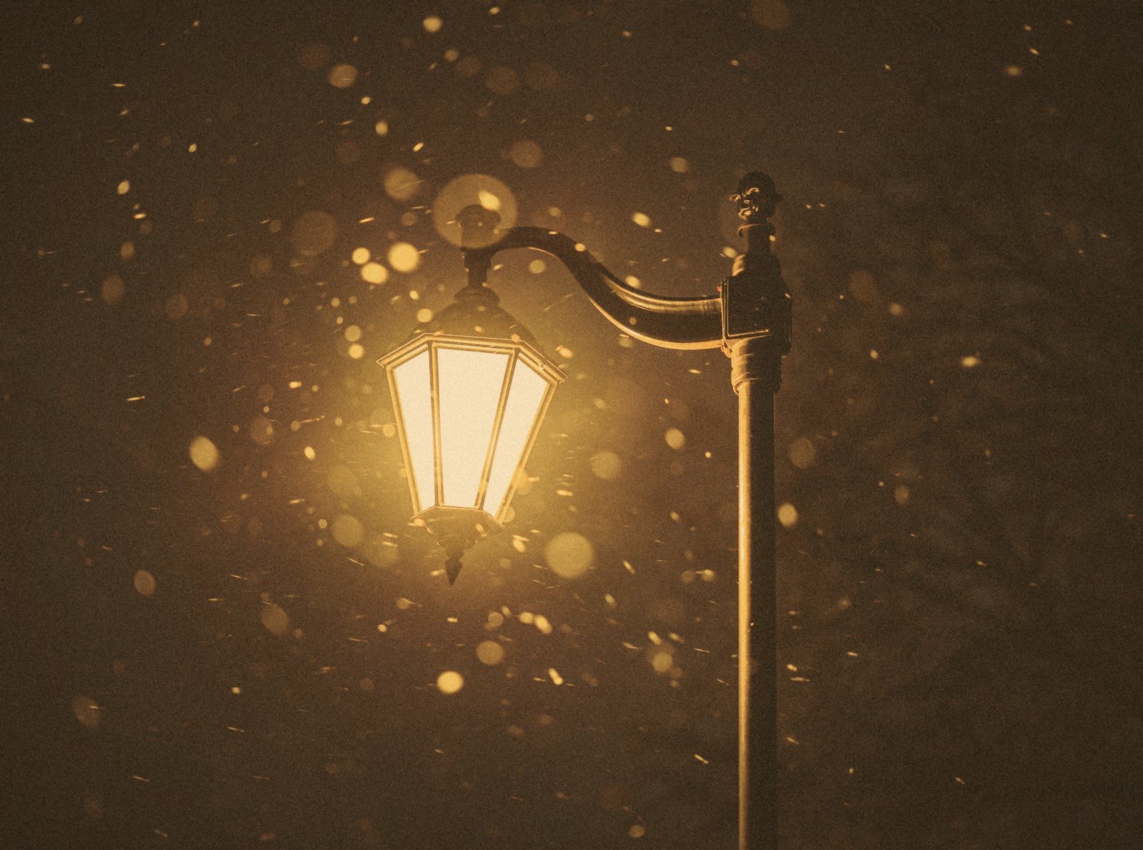 Farola encendida en una noche de nieve